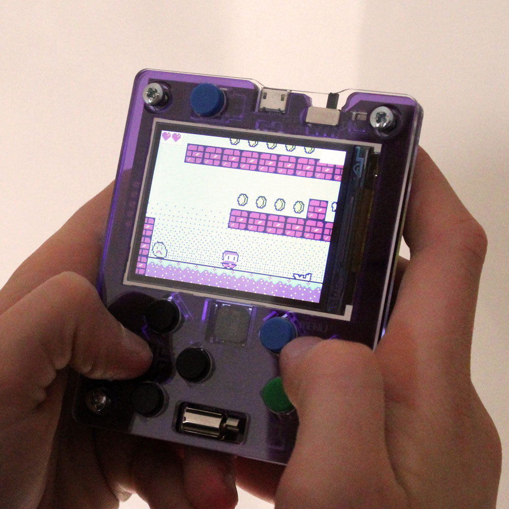 Student using the Kitronik ARCADE Max handheld coding and gaming console with a retro-style MakeCode Arcade game displayed on screen